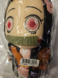 Close-up of Demon Slayer Nezuko Kamado 8-inch plush doll face through poly bag showing embroidered pink eyes with white ring accents black eyelashes and ribbed green bamboo muzzle detail by Great Eastern Entertainment