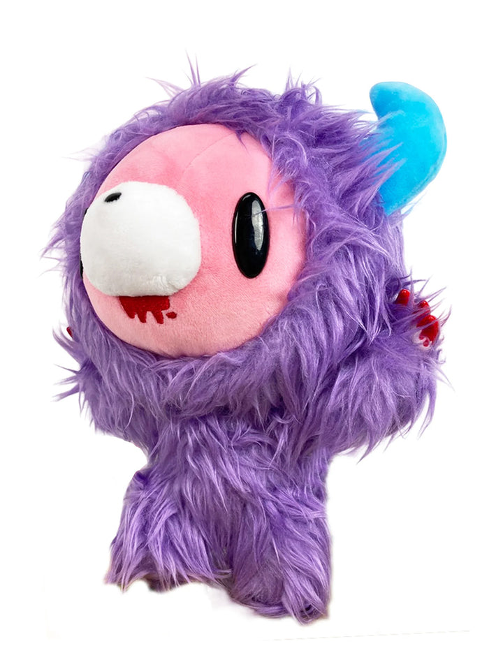 A cute plush toy resembling a small creature with purple fur, a pink face, and a blue horn on the side. It has large black eyes and a quirky expression.
