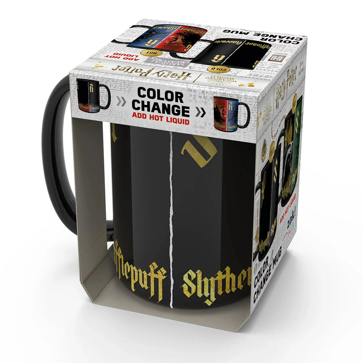 A boxed ceramic mug with a black handle and black body, shown inside its retail packaging on a white studio background. The mug features Slytherin gothic lettering and a vertical split design with gold and black sections.