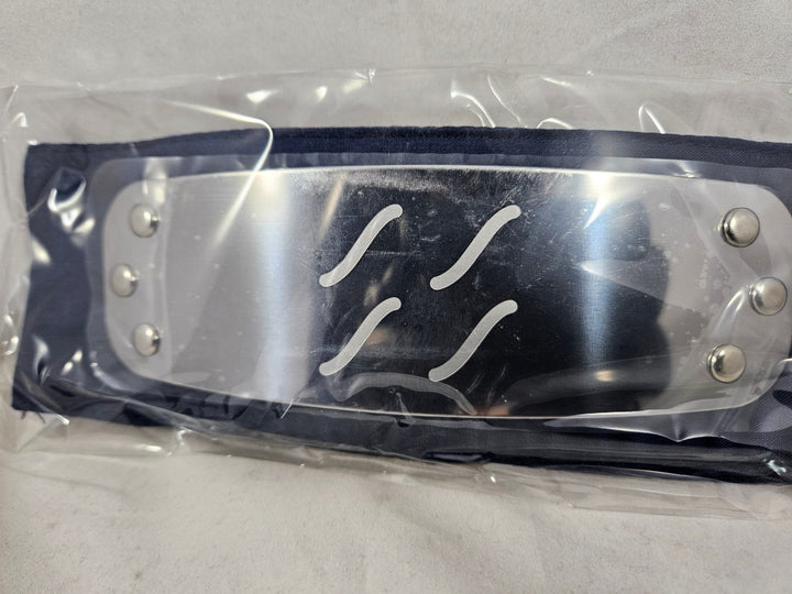 Close up of Naruto Mist Village headband with metal plate engraved with Mist Village Kirigakure symbol and packaged in plastic on a gray background
