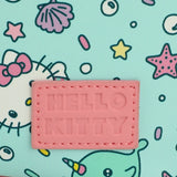 Pink 'HELLO KITTY' patch on a colorful background with cartoon characters.