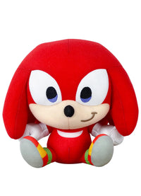 A plush toy of the character Knuckles from Sonic, featuring his signature red body, cream-colored snout and hands, and gray feet with red, yellow, and green accents, set against a plain white background.