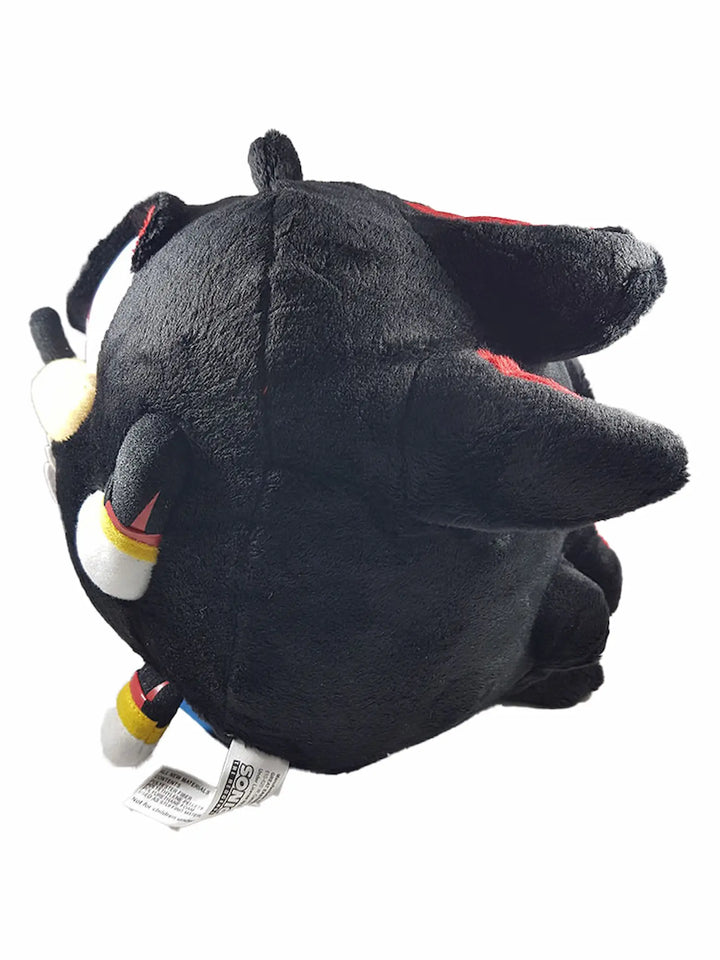 A black plush toy with pointed ears, white gloves, and small red and yellow details, shown against a plain white background.
