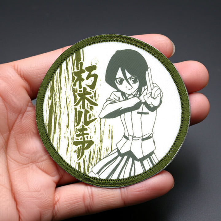 Circular patch with an anime-style character held in a hand against a dark background