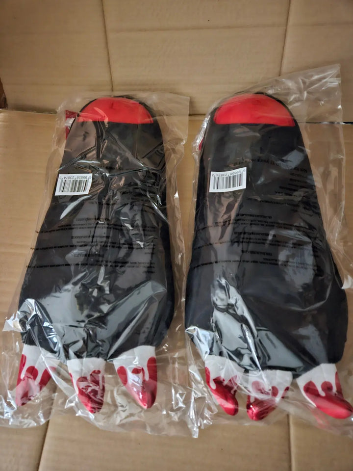 Reverse view of two individually packaged Gloomy Bear black plush paw arm gloves showing separate barcode stickers and red-tipped white claws, Great Eastern Entertainment.