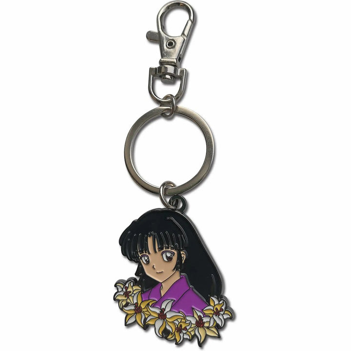 An anime keychain charm featuring a character with black hair and a purple top surrounded by white and yellow flowers, attached to a silver metal split ring and lobster clasp on a white background.