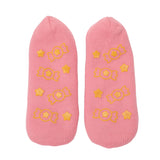 Pink ankle socks with yellow candy and star patterns. The playful design and vibrant colors evoke a cheerful and whimsical feel.