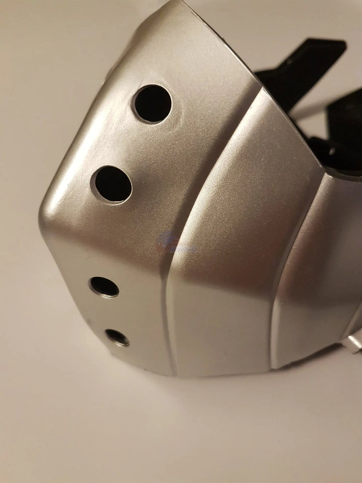 A close-up of a metallic silver protective face mask or helmet shell with circular ventilation holes, shown on a plain light background.