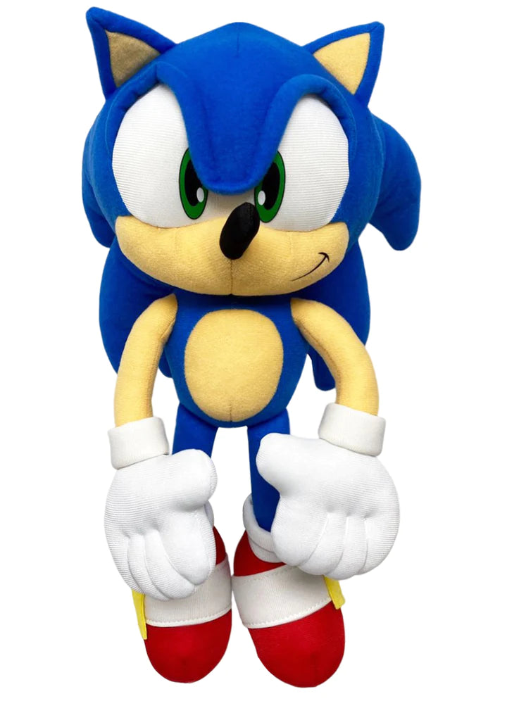 Plush toy of a blue hedgehog character with large eyes, white gloves, and red shoes, smiling with a playful expression against a plain background.